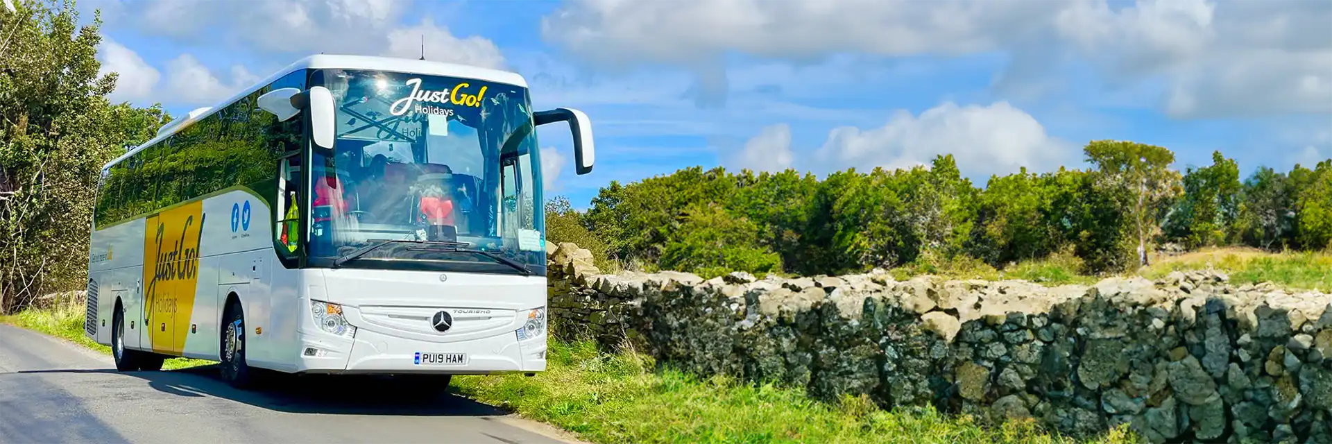 A Just Go! Holidays coach in a countryside setting.